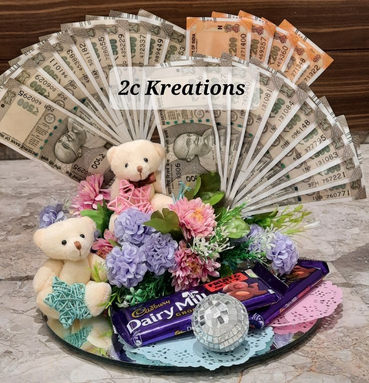 two teddy bears sitting on top of a plate filled with candy and flowers next to money