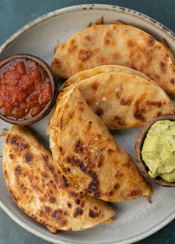 some tacos and guacamole on a plate