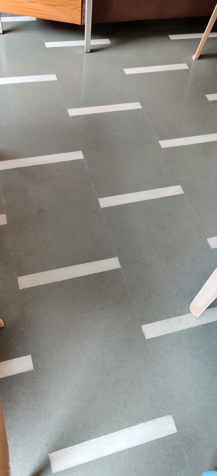 the floor is covered with strips of white tape and some chairs are in the background