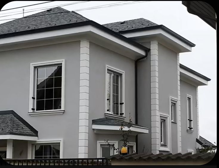 a large white house with two story windows and a black fence in front of it