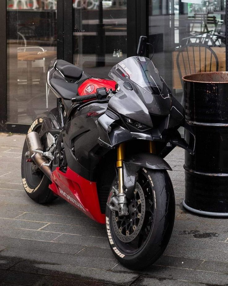 a red and black motorcycle parked on the street