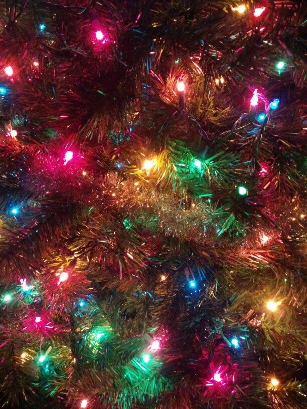 the top of a christmas tree with multicolored lights