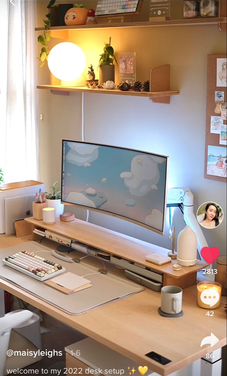 a desktop computer sitting on top of a wooden desk in front of a large window