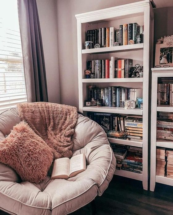 a chair with a book on it in front of a bookshelf filled with books