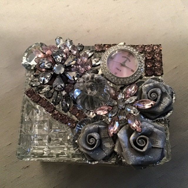 a close up of a small glass box with flowers and jewels on the inside,