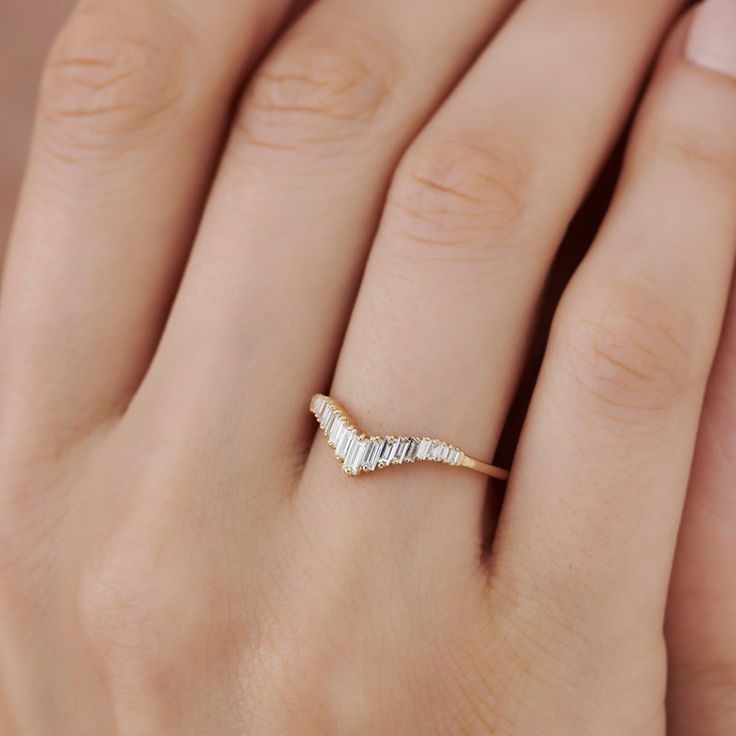 a woman's hand with a gold and white diamond ring on it, showing the band