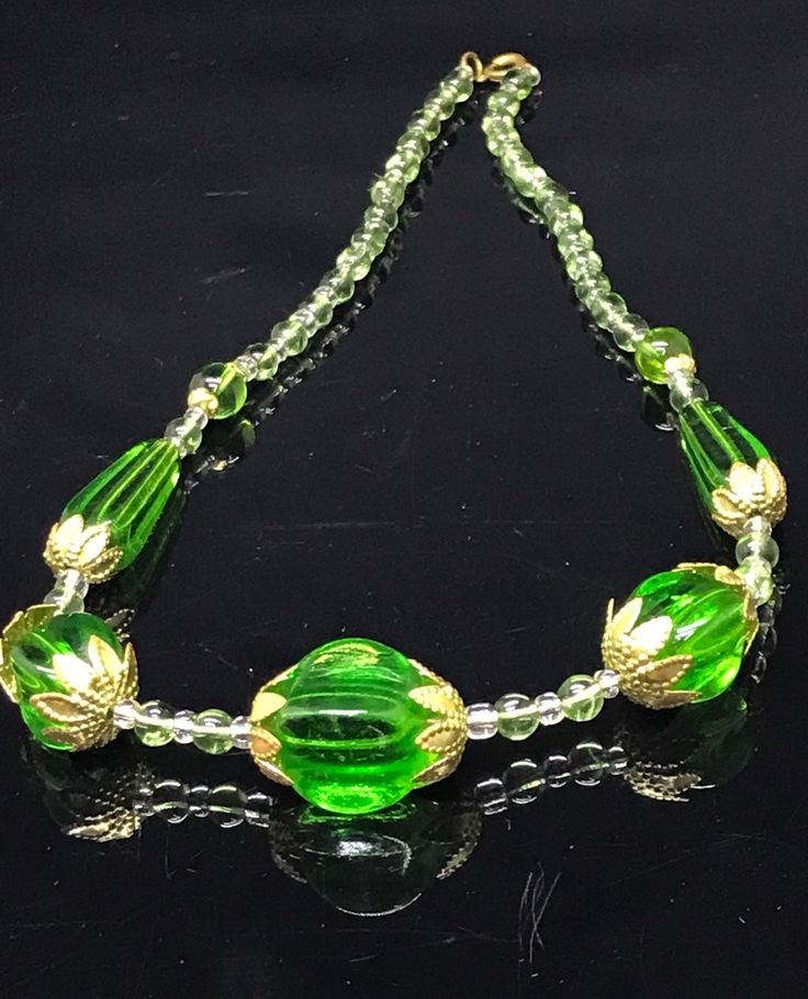 Very pretty vintage green faceted crystal necklace  with a spring ring clasp : signed on clasp . ( Czech) Total length approximately 45Cm  Extremely large moulded/ faceted crystals largest measures approximately 2 Cm x 1.5 Cm and long green beads are 3 cm long. A chunky and unusual vintage necklace set with large gold tone metal accent bead caps and small glass beads . On the original string , good clean condition. Signed Czech necklaces are becoming scarce. Gift wrapped and ready to wear Green Single Strand Necklace For Formal Occasions, Formal Green Single Strand Beaded Necklace, Formal Green Beaded Necklace, Green Glass Round Bead Jewelry, Formal Green Beaded Necklace With Faceted Beads, Green Single Strand Jewelry For Party, Formal Green Faceted Beaded Necklaces, Single Strand Green Jewelry For Party, Vintage Green Glass Beaded Necklaces