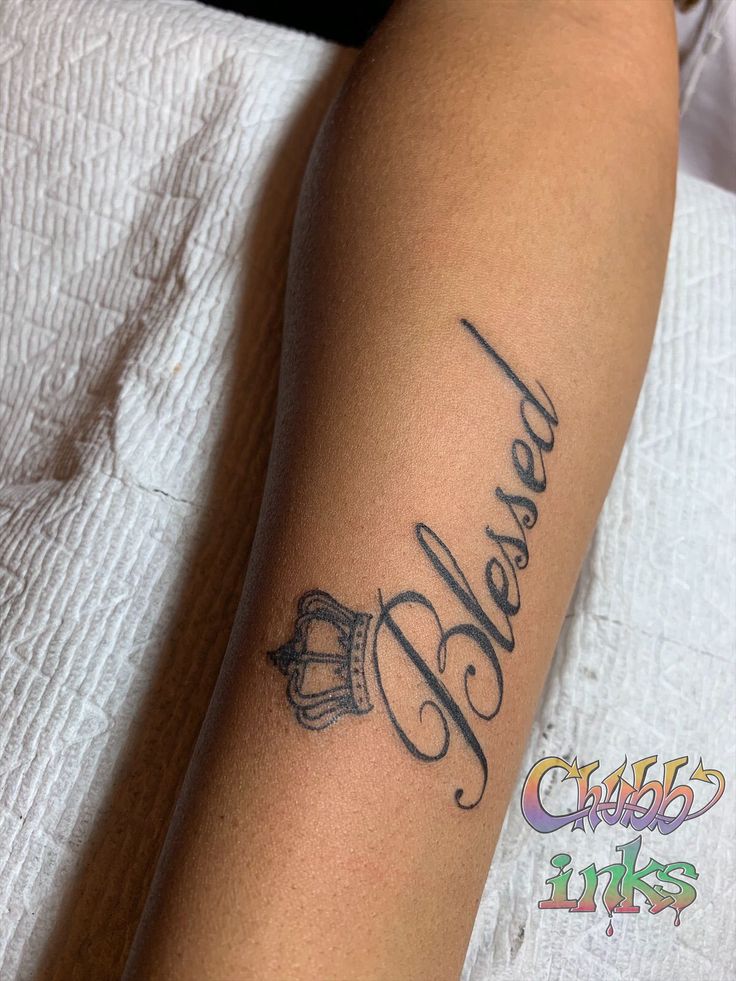 a person with a tattoo on their arm that says, dearly and crown in cursive writing