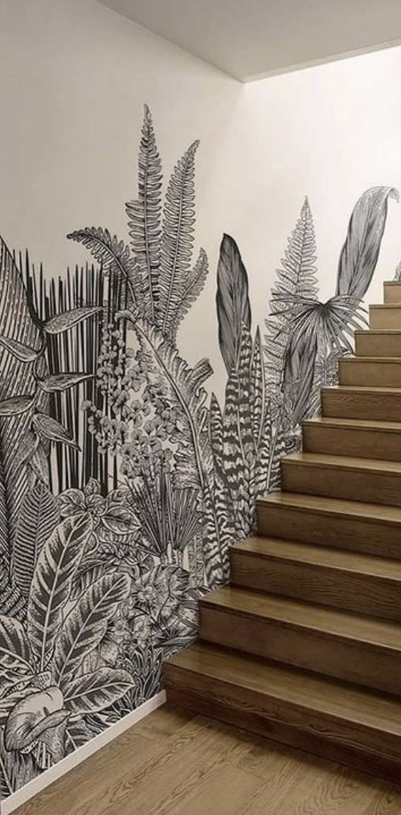 a stair case with plants painted on the wall and wooden steps leading up to it