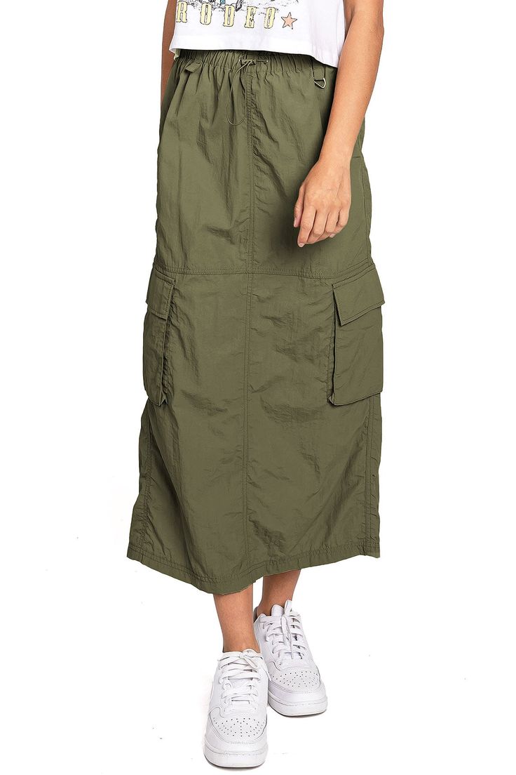 Chic, parachute skirt with an elastic waistband, a drawstring cinch tie and cargo pockets down the sides. Pair it with a graphic tee and sneakers for an effortless streetwear look. CARE | Machine Wash Cold CONTENTS | 100% Nylon MEASUREMENTS | 33"/85 cm Top to Bottom (Size Small) MODEL | 5'8 - wearing a size Small IMPORTED Summer Utility Cargo Skirt With Drawstring, Casual Cargo Skirt With Drawstring For Summer, Casual Drawstring Cargo Skirt For Summer, Casual Summer Cargo Skirt With Drawstring, Spring Utility Cargo Skirt With Drawstring, Casual Cargo Skirt With Pockets, Summer Streetwear Cargo Skirt, Casual Khaki Cargo Skirt With Pockets, Casual Khaki Cargo Skirt With Side Pockets