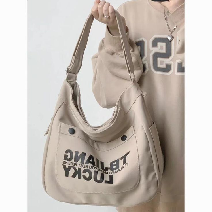 Product information: Style: Casual/Street/Preppy/Vintage/Hip PopOccasion: Weekend Casual/Going Out/Holiday/Travel/School Material: Oxford cloth Size: upper width 39. lower width 33. height 30. thickness 19CM; Weight 0.28kg. Portable vertical height 4. shoulder strap 110 shoulder strap size is the longestDescription:Outfit yourself in a style that's Casual. Street. Preppy. Vintage. or Hip Pop with this Oxford cloth Letters Large Canvas Crossbody Bag! Perfect for the Weekend. Going Out. Holidays. Travel. or School - this bag has a width of 39cm at its upper point. 33cm at its lower point. is 30cm high. and has a thickness of 19cm. With a weight of 0.28kg and a shoulder strap size of 110cm (longest size). you'll be ready for adventure in no time! Stylish School Bags, My Style Bags, Back To School Bags, Skirt And Sneakers, Canvas Messenger Bag, Fancy Bags, Canvas Crossbody Bag, Pretty Bags, Fashion Board