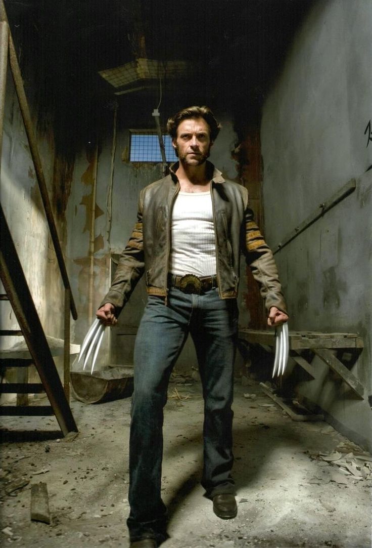 a man with wolverine's claws standing in an alley