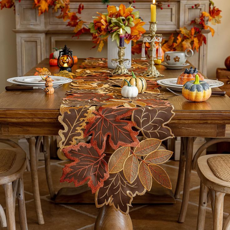 a dining room table decorated with fall leaves