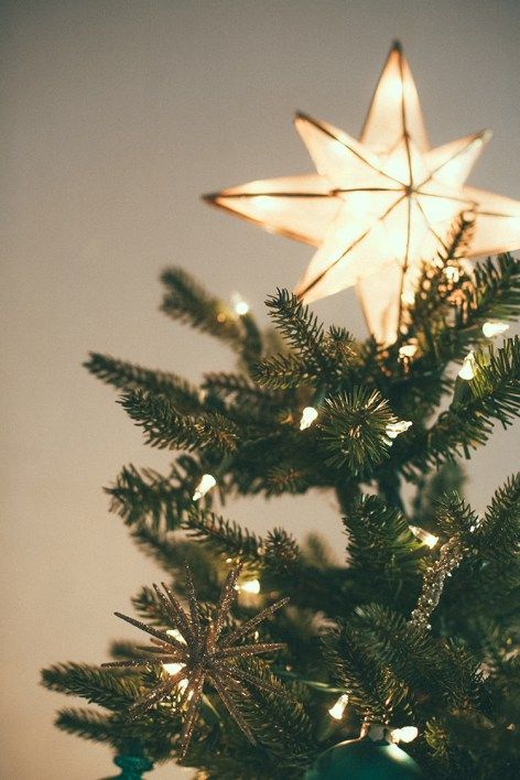 a star ornament on top of a christmas tree