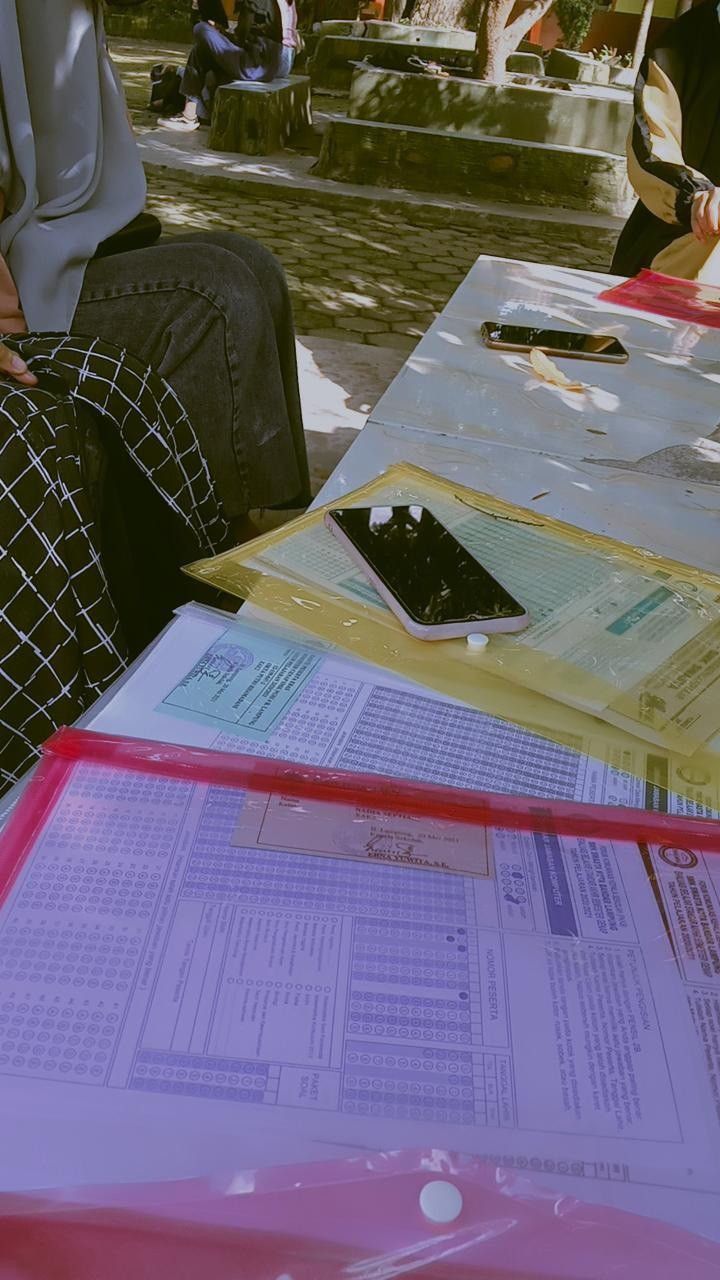 two people sitting at a table with papers on it