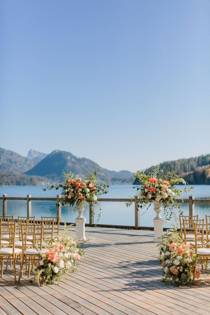 an outdoor ceremony set up with chairs and flowers on the aisle, overlooking lake luganoni