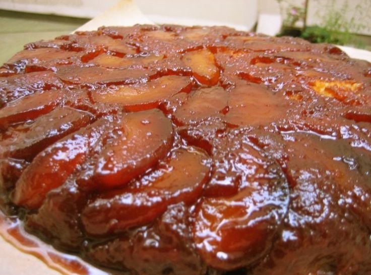 there is a large cake covered in sauce on the table with other food items around it