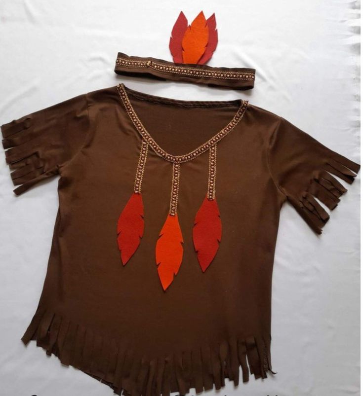 a child's brown shirt with orange feathers and chains on the neck, along with a headband