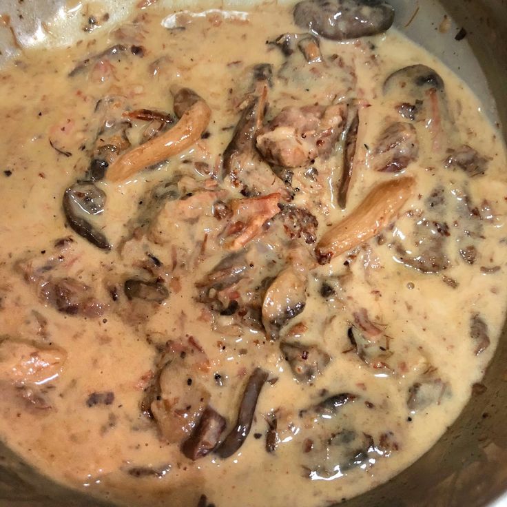 a bowl filled with meat and mushrooms covered in gravy