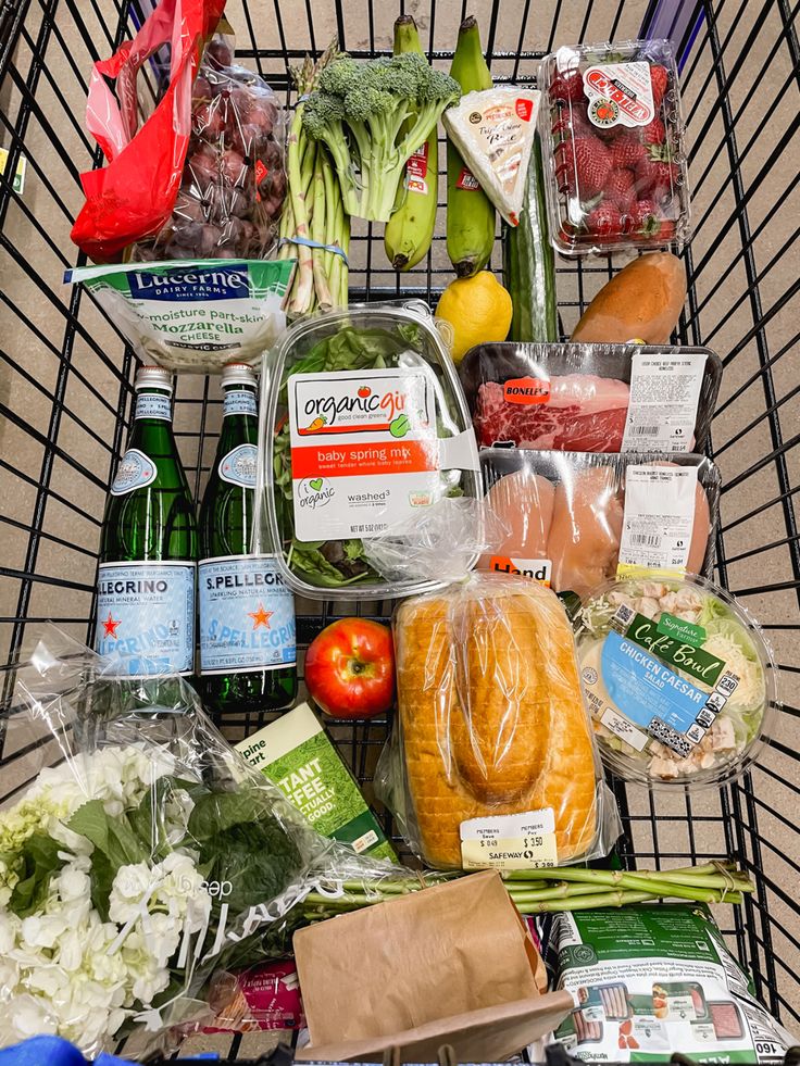 a shopping cart filled with groceries and vegetables