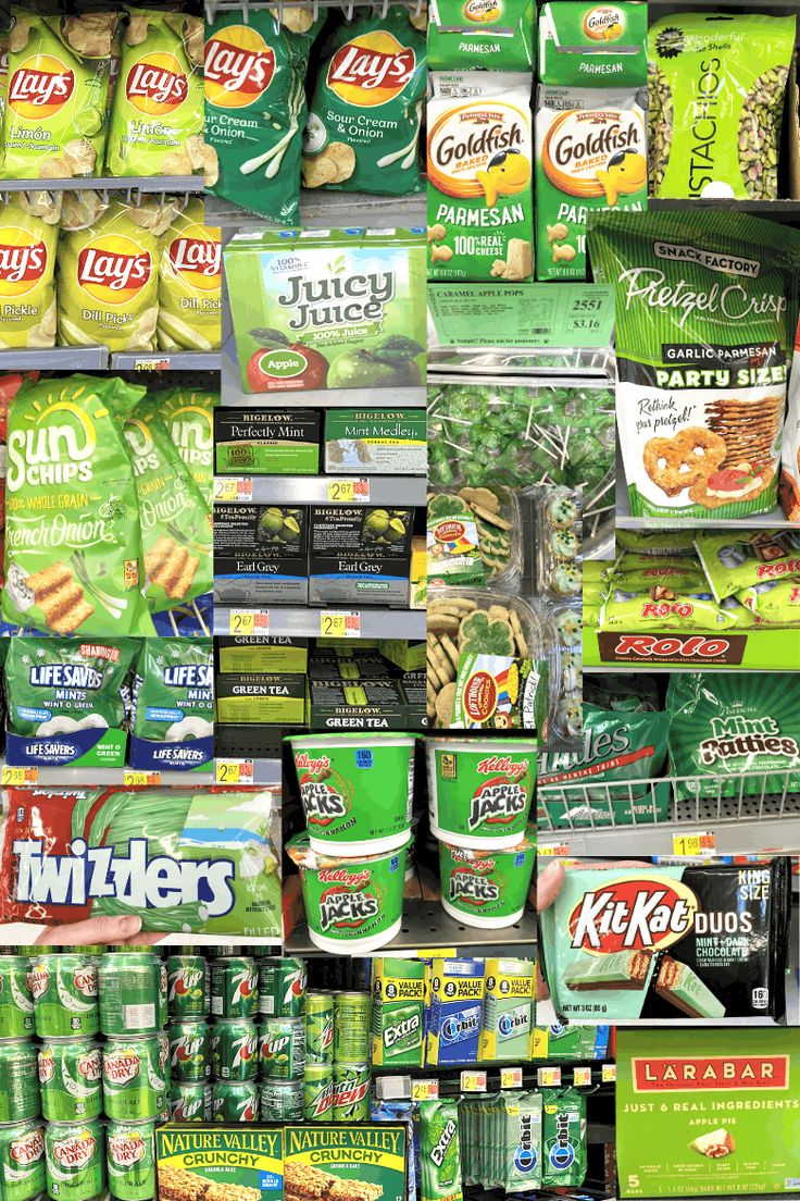 a display in a grocery store filled with lots of green food and drink items on shelves