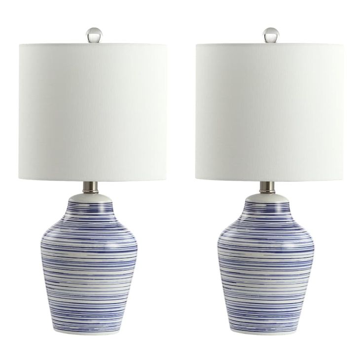 two blue and white vases with lamps on top of each one, side by side