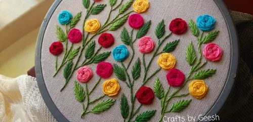 a close up of a embroidery on a piece of cloth with flowers in the middle