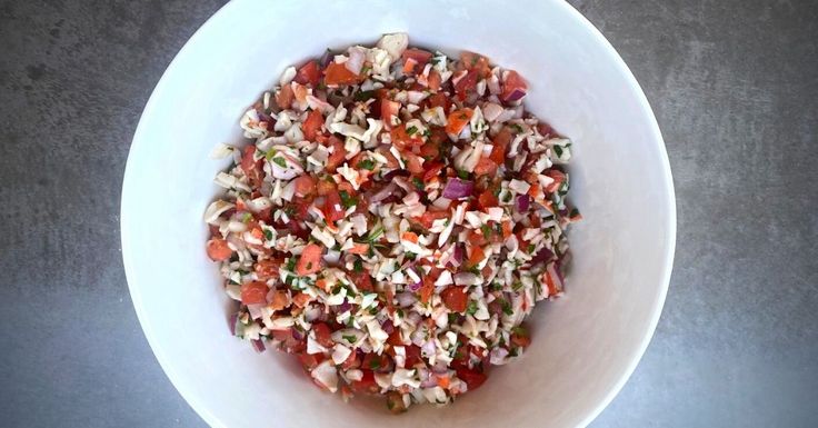 a white bowl filled with chopped vegetables on top of a table