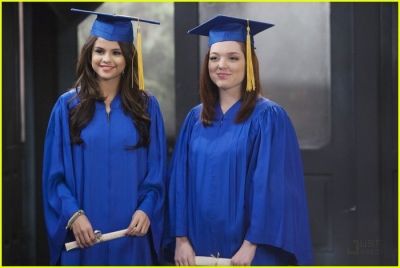 two women in blue graduation gowns and caps