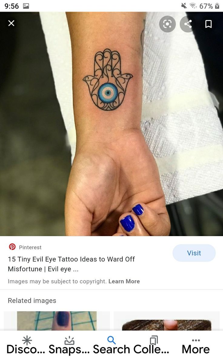 a hand with an evil eye tattoo on it