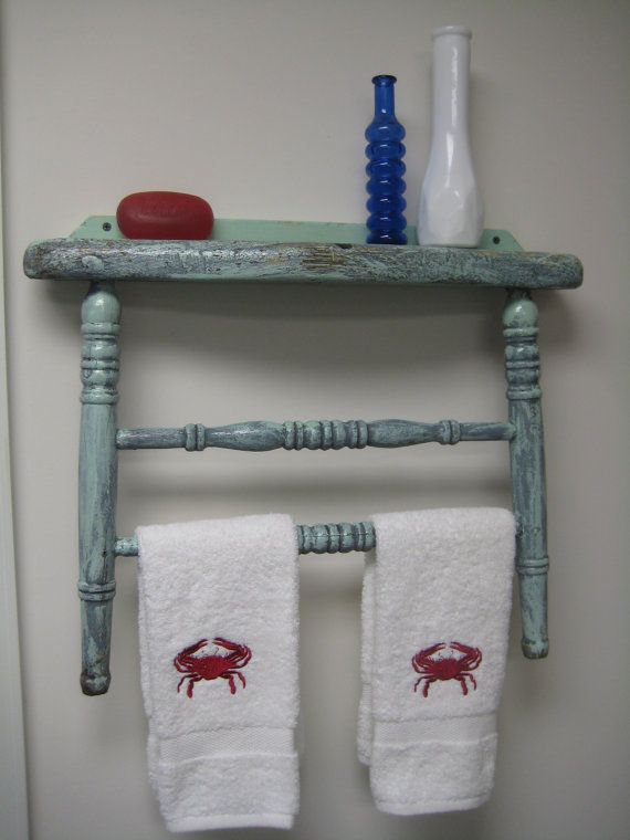 two crab towels are hanging on an old wooden shelf