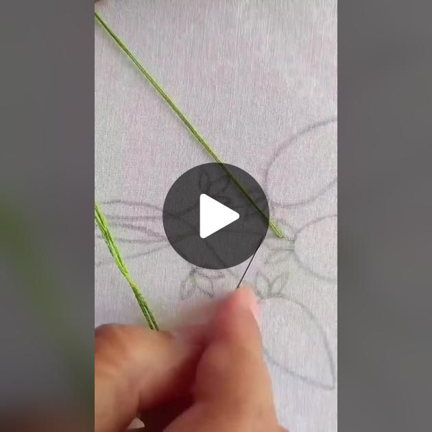 someone is stitching something with green thread on a piece of paper that has been embroidered onto it