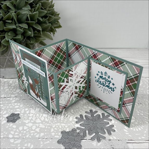 an open christmas card with snowflakes on it and a tree in the background