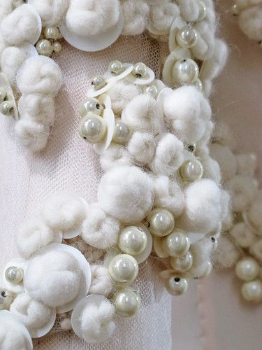 a white dress with pearls and buttons on it