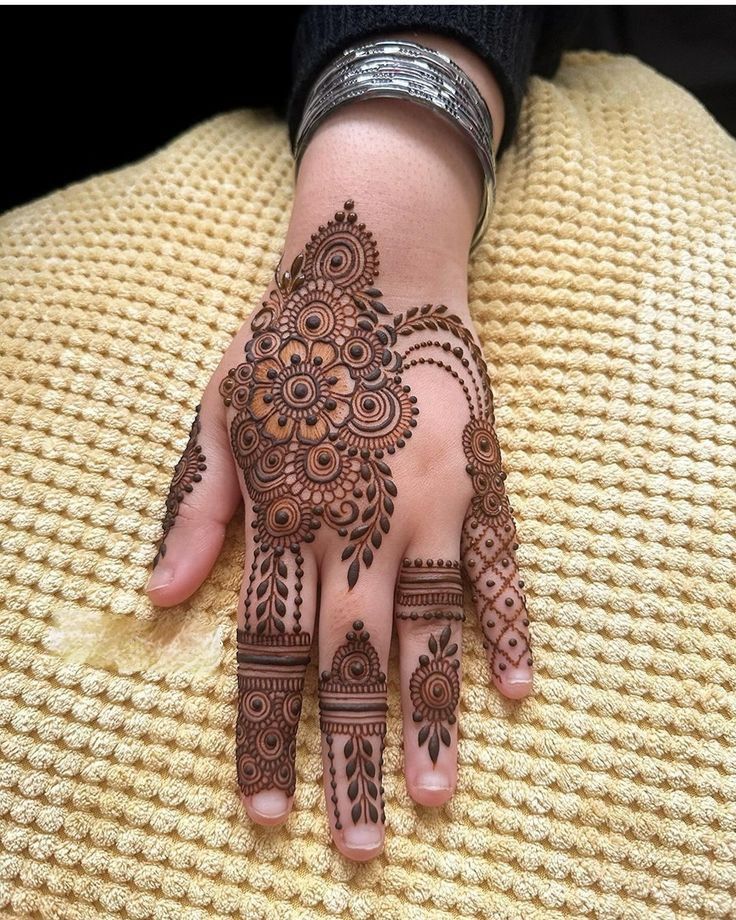 a woman's hand with henna tattoos on it