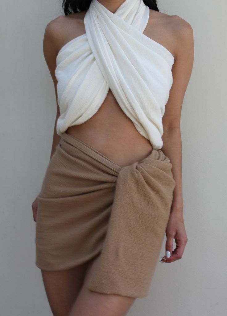 The Ellie Sarong is our most versatile piece yet and was inspired by our love of waffled cotton, which we wanted to make available in as many styles as possible. We envision the Ellie as a year-round accessory that can be tied as a halter or bandeau top, easy sarong skirt or cover-up, or draped as a classic shawl or scarf. Ideal for a variety of settings - from everyday summer comfort to luxurious resort wear. Pair with coordinating Bobbie Wrap Skirt, Chloe Shorts, or Patricia Pants for a sophis White Cotton Tie-back Halter Top, Scarf Skirt, Honeycomb Texture, Luxurious Resort, Sarong Skirt, Scarf Top, Wrap Scarf, Cotton Scarf, Bandeau Top