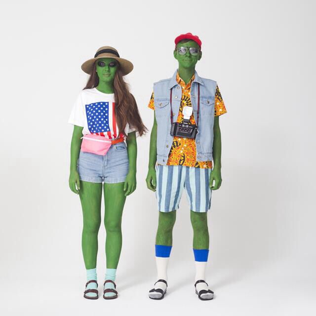 two people are dressed in green and white outfits, one is wearing an american flag t - shirt