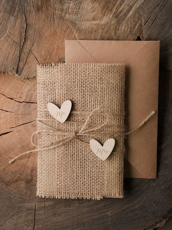 two wooden hearts tied to a piece of burlock on top of a card