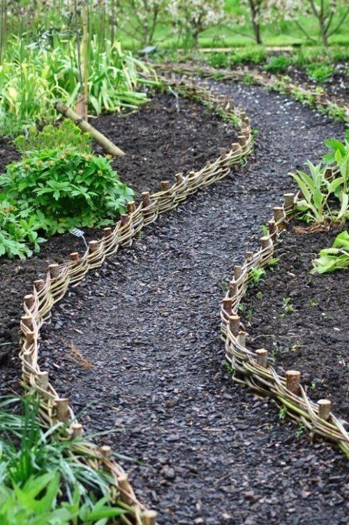 an image of a garden path made out of sticks and plants in the middle of it