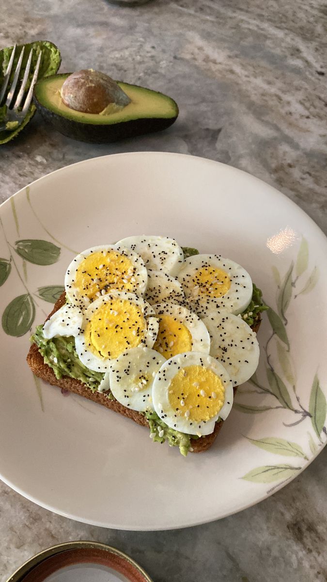 an egg and avocado sandwich is on a plate