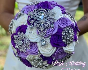 the bride's bouquet was made up of purple and white roses, brooches, and pearls