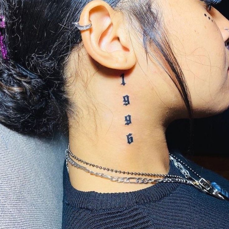 a woman with tattoos on her neck and behind the ear