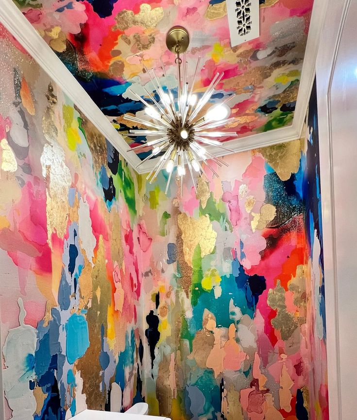 a bathroom with colorful paint on the walls and ceiling, along with a chandelier