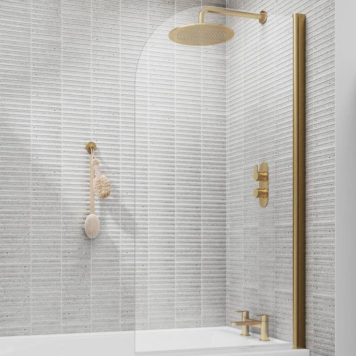 a bathroom with white tile and gold fixtures