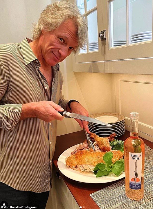 a man cutting food on top of a white plate with a knife and fork in it