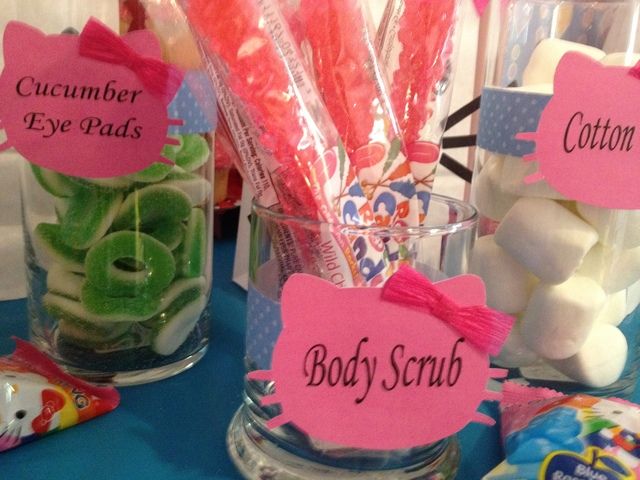 some candy and candies are sitting in glass vases on a blue tablecloth