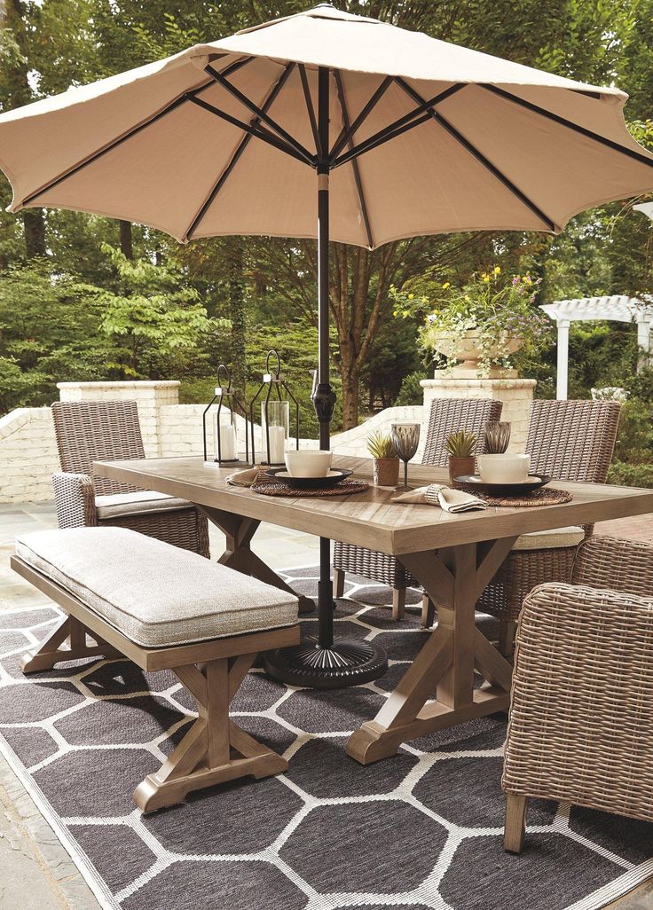 an outdoor dining table with chairs and umbrella