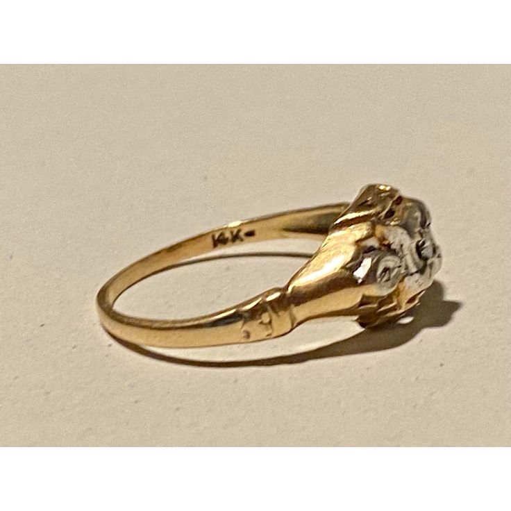 a yellow gold ring with a skull on it's face and two claws in the middle