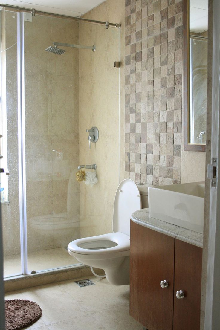 a white toilet sitting next to a walk in shower