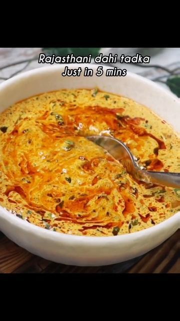 a white bowl filled with food on top of a wooden table